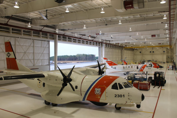 Airbus Military HC-144A, Dassault HU-25C, et Sikorsky MH-60J dans un hangar commun de CGAS Cape Code.