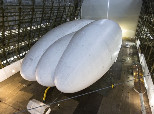 CARRINGTON, ENGLAND - FEBRUARY 28:  Mike Durham, the Technical Director at Hybrid Air Vehicles, admires the helium-filled 'Airlander' aircraft in a giant airship shed on February 28, 2014 in Cardington, England. The Airlander, which was originally developed for the US military before the project was cancelled due to budget cuts, is the world's longest aircraft at 92 meters. Although slow moving compared to conventional aircraft, the Airlander is able to carry large payloads over long distances very efficiently. Hybrid Air Vehicles' project to develop the technology further is being funded by a Government grant as well as private finance from individuals including Bruce Dickinson, the lead singer of the band Iron Maiden.  (Photo by Oli Scarff/Getty Images)