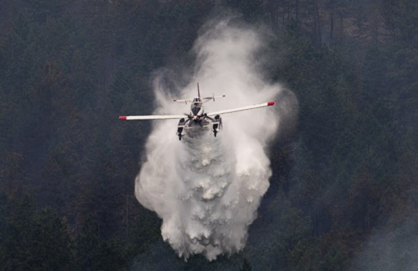 A water bomber drops water on a hillside in West Kelowna, B.C. Friday, July, 18, 2014. Over 2500 residents of the area were evacuated when the fire suddenly grew in size threatening nearby homes. THE CANADIAN PRESS/Jonathan Hayward ORG XMIT: JOHV113