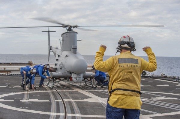 Un chien jaune des gardes-côtes en action face à un MQ-8B.